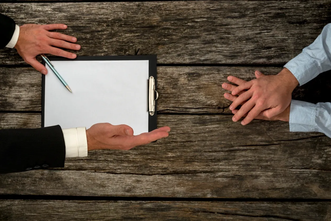 Business discussion over clipboard on wooden table