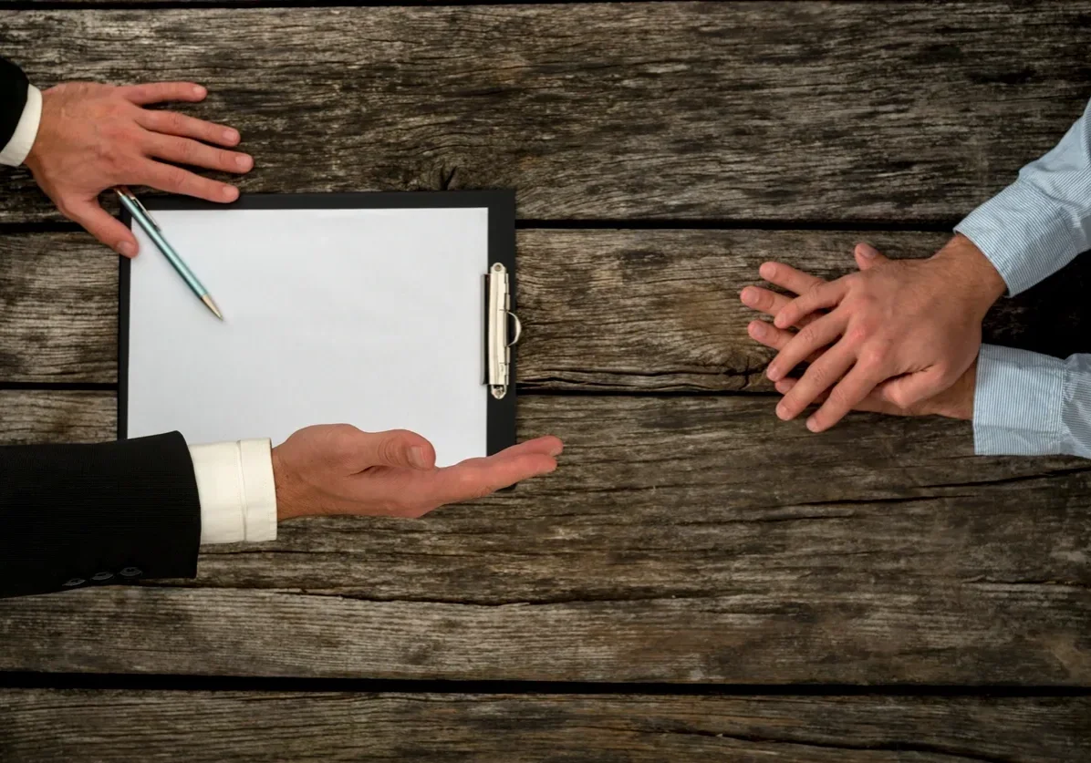Business discussion over clipboard on wooden table